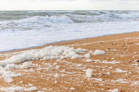 Windswept sea foam on a beach in the Atlantic Ocean near Olonne sur mer in Franceの写真素材