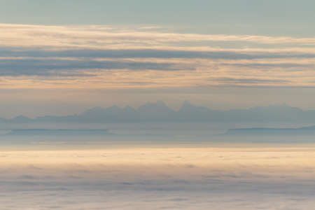 Silhouette of the Alpine chain on the horizon seen from the Vosges mountains above a sea of fog....