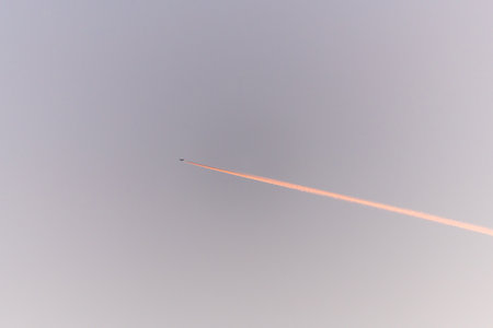 Airliners in flight in a cloudy pink and orange sky in late summer. France.の写真素材