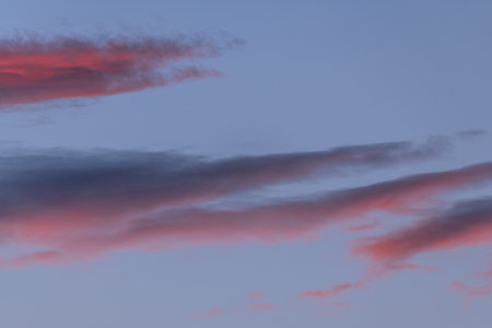 Colorful clouds are formed in evening sky, presenting shades of red and blue. This natural spectacle...