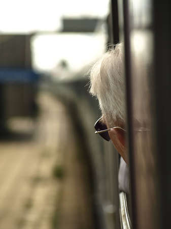 Old man looks outside the train.の写真素材
