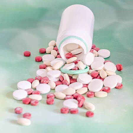 Red, white, yellow drugs pills with white open plastic bottle, powder, bunch, medical, homeopathic,...