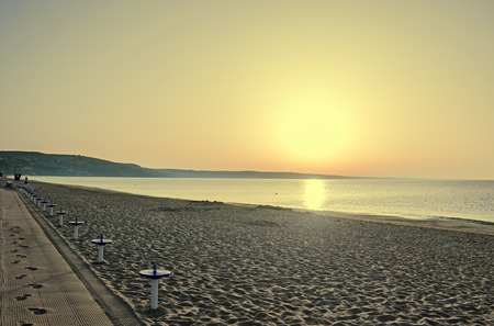 Sunrise on seaside, sand and clear water, the shore of Black Sea, orange sky lightsの写真素材