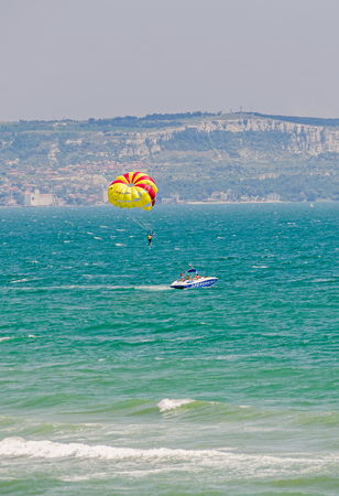 ALBENA, BULGARIA - JUNE 19, 2016. Colored parasail wing pulled by a boat in the blue water seaのeditorial素材
