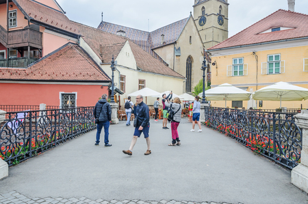 SIBIU, ROMANIA - AUGUST 10, 2016: Liars Bridge near downtown with old colored housesのeditorial素材