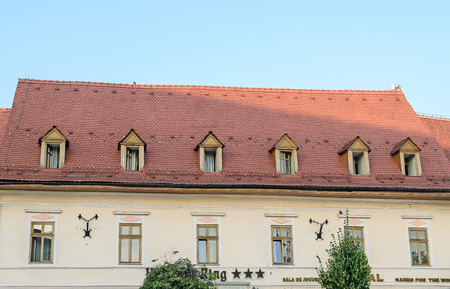 SIBIU, ROMANIA - AUGUST 10, 2016: Detail of houses situated near downtown of the city. Roof with colored windowsのeditorial素材