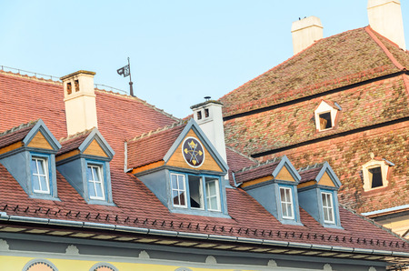SIBIU, ROMANIA - AUGUST 10, 2016: Detail of houses situated near downtown of the city. Roof with colored windowsのeditorial素材