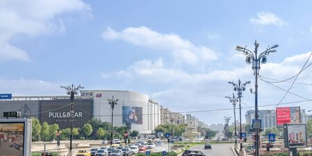 BUCHAREST, ROMANIA - SEPTEMBER 19, 2015. The square "Piata Unirii" with shops, traffic cars, tourists and outdoor fountains.のeditorial素材