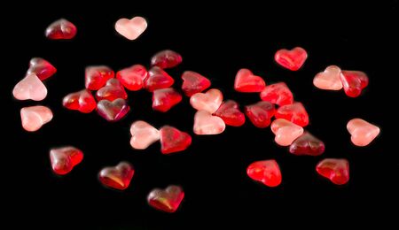Colored (pink, red and orange), transparent heart shape jellies, close up, texture.の写真素材