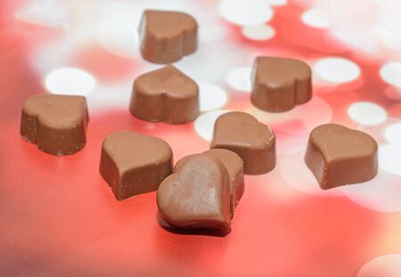 Heart shape chocolate, Valentines Day sweets, brown red background.