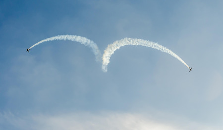 BUCHAREST, ROMANIA - OCTOBER 4, 2014: Aerobatic airplane pilots training in the sky of the city. Colored airplane with trace smoke.のeditorial素材