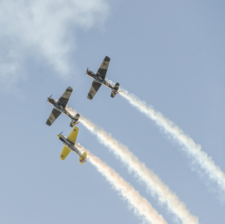 BUCHAREST, ROMANIA - OCTOBER 4, 2014: Aerobatic airplane pilots training in the sky of the city. Colored airplane with trace smoke.のeditorial素材