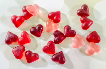 Colored (pink, red and orange), transparent heart shape jellies, close up, texture.の写真素材