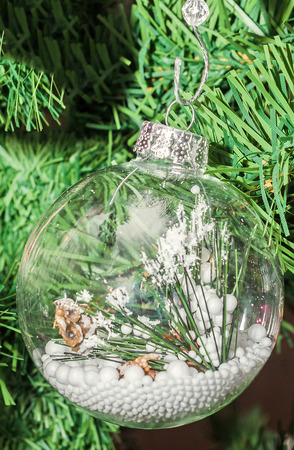 Detail of green Christmas (Chrismas) tree with colored ornaments, globes, stars, Santa Claus, Snowman, red boots, shoes, candles, bells, white transparent angels, snow flakes and candy sticksの写真素材