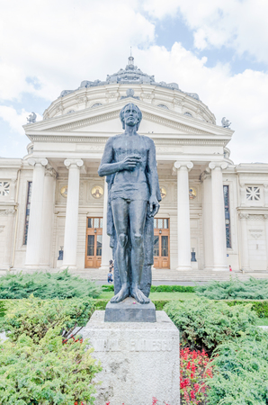 BUCHAREST, ROMANIA - MAY 25, 2014: The statue of Mihai Eminescu in front of the Building called "Ateneul Roman". Romanian Athenaeum.のeditorial素材