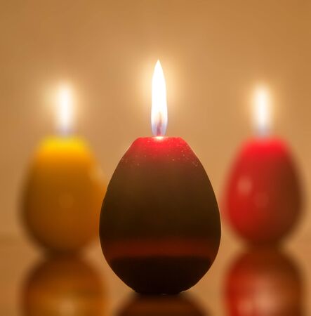 Easter candles egg shape with flame, candles light.の写真素材