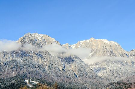 Romanian Carpathian mountains, Bucegi range with clouds, snow and fog, winter time landscape.
