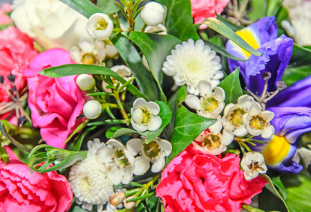 Floral arrangement with colored flowers roses, iris, chrysanthemums, Carnations, green leafs.