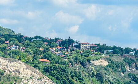 The Black Sea shore, green hills with houses, blue clouds sky. City Balchik coast.の写真素材