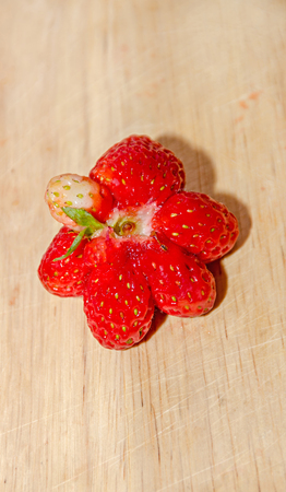 Star shape red strawberry fruit, rustic wood background, close up.の写真素材