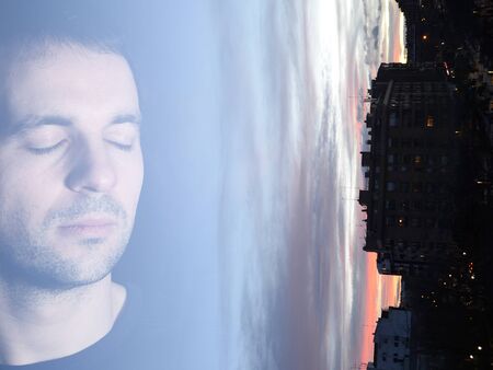 Peaceful man with closed eyes over urban landscape at twilight. Double exposure photography