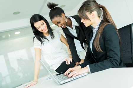 Businesswomen exchanging thoughts in a nice office environment while working on a laptopの写真素材