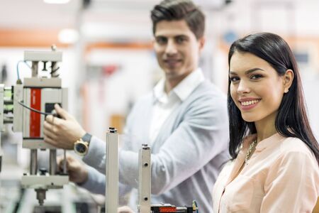 Two young students working on a science project together in labの写真素材