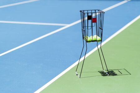 Beautiful tennis court with a ball basket and tennis balls in itの写真素材