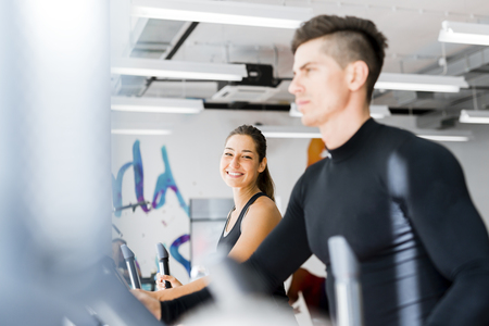 Young healthy group of people working out on a elliptic trainer in a fitness centerの写真素材