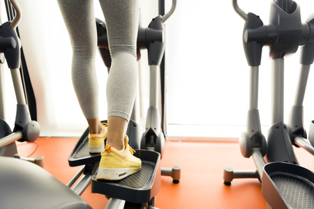 Closeup of a woman using a stepper and training in a fitness centerの写真素材