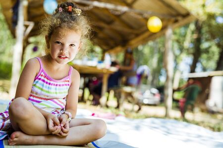 Beautiful curly haired young girl smiling outdoorsの写真素材