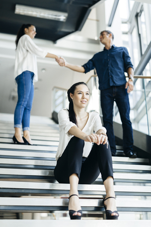 Group of business people shaking hands on stairs in a beautiful modern officeの写真素材