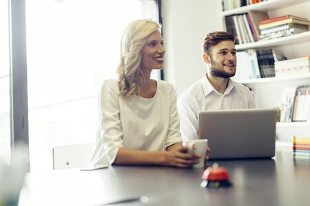 Cheerful coworkers in office during company meeting