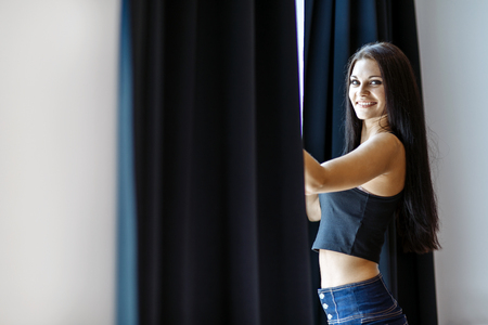 Happy beautiful young woman staring out the windowの写真素材
