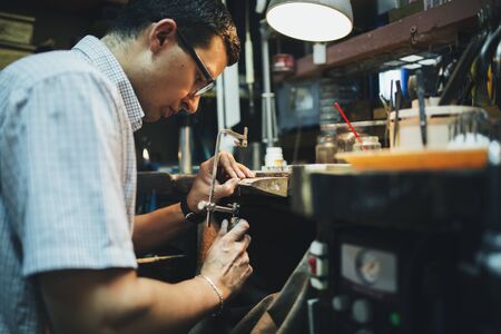 Jeweler desining jewelry in workshopの写真素材