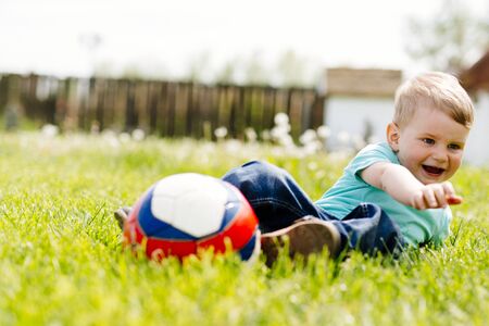 Adorable small boy playing with a soccer ball outdoorsの写真素材