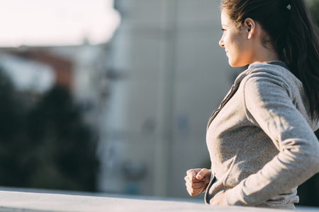 Beautiful female jogging in city and keeping her body in shapeの写真素材