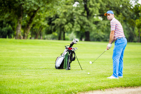 Golfer practicing and concentrating before and after shot during a nice sunny dayの写真素材
