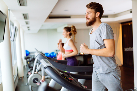 People running on treadmill in gym doing cardio workoutの写真素材