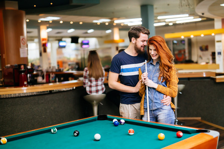 Beautiful couple spending time together by playing poolの写真素材