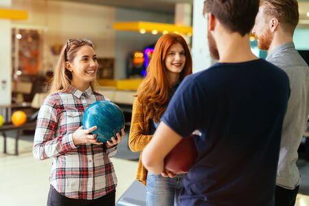 Cheerful friends bowling together and bondingの写真素材