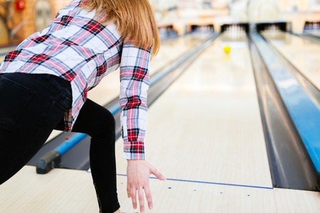 Woman throwing bowling ball in clubの写真素材