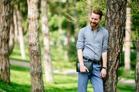 Businessman using tablet in city park