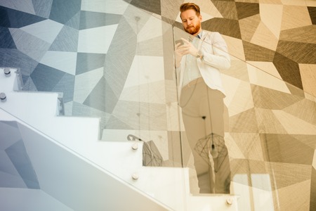 Businessman having tablet and phone constantly at hand to stay up to dateの写真素材