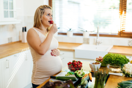 Pregnant woman healthy eating vegetables and fruitの写真素材