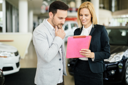 Customer looking for a car at dealership and customizing vehicleの写真素材