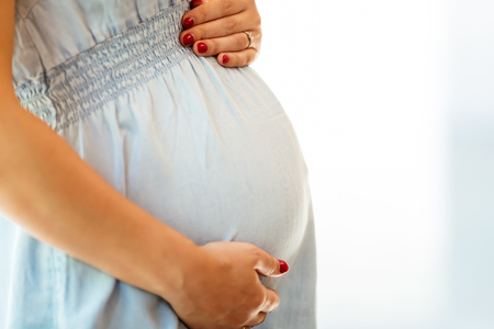 Beautiful pregnant woman holding her bellyの写真素材