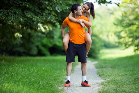 Man carrying woman piggyback after jogging is doneの写真素材