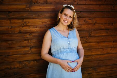 Beautiful blond pregnant woman holding her bellyの写真素材