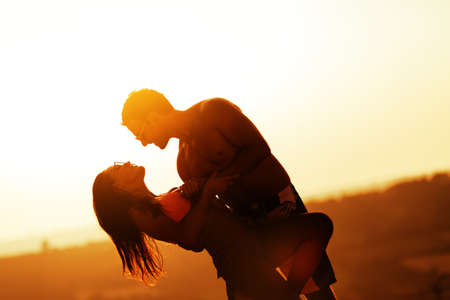 Romantic dance at sunset by couple in swimsuit